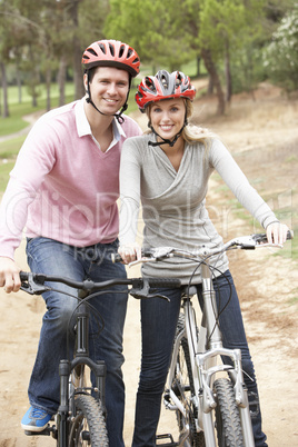 Couple riding bicycle in park