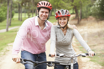 Couple riding bicycle in park