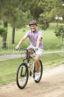 Senior man enjoying bike ride in park