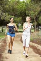 Two young women running in park