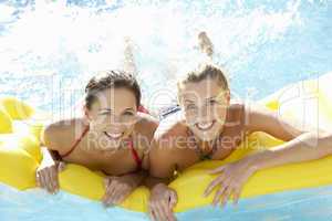 Two women friends having fun together in pool