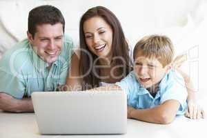 Young parents, with child, on laptop computer