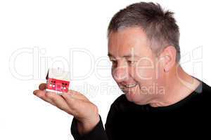 Mann mit Miniaturhaus auf der Hand 118a