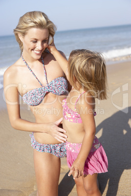 Mother playing with young girl on beach