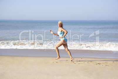 Senior woman running on beach