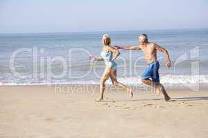 Senior couple running on beach