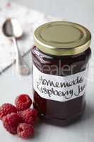 A still life of raspberry jam in jar