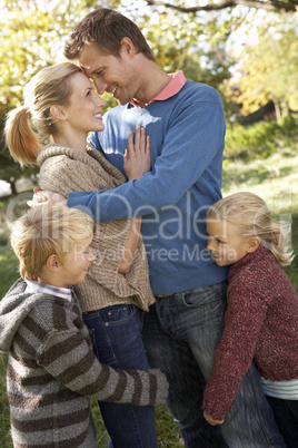 Young family pose in park