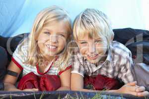 Young children pose in tent