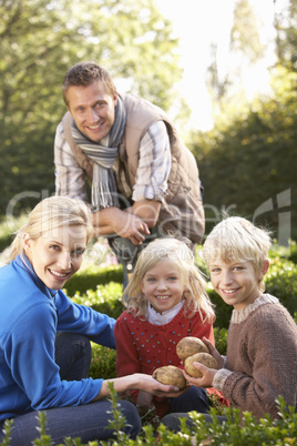 Young family sit together in garden