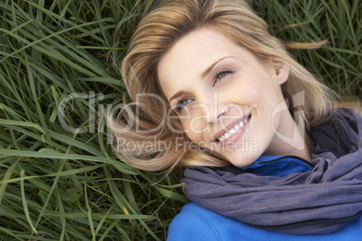 Young woman lying alone on grass