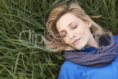 Young woman napping alone on grass