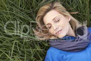 Young woman napping alone on grass