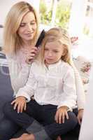 Woman combs hair of young girl