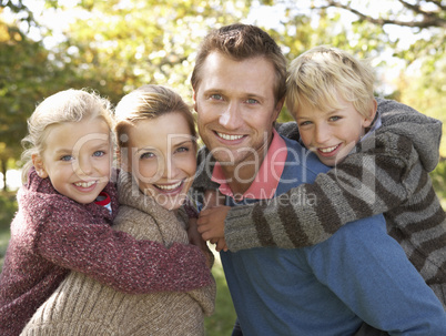 Young family pose in park