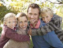 Young family pose in park