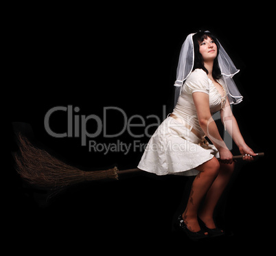 bride in white wedding dress on a broom