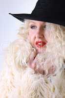 Curly blonde in a black hat and white fluffy fur coat