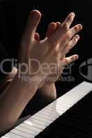 Hands above keys of the piano. A photo close up
