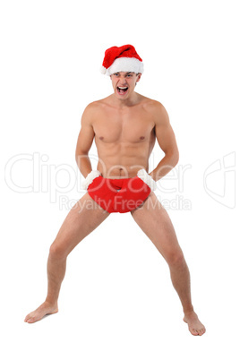 Sexy muscular man screams wearing a Santa Claus hat