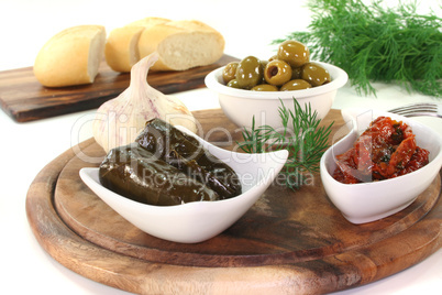 Oliven, gefüllte Weinblätter und eingelegte Tomaten