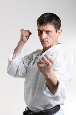 Karate. Man in a kimono with a white background