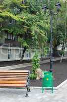 Wooden benches, green refuse bin
