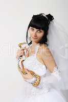 bride in a white dress with a snake boa in his hands