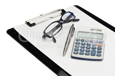 Angled note pad, pen, glasses and pocket calculator