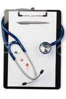 Note pad and stethoscope with pen at the top and pills