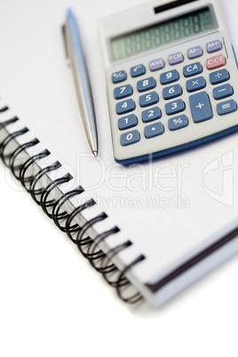 Angled notebook with pencil and pocket calculator