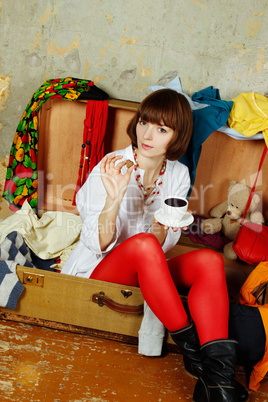 Attractive woman sitting in a suitcase