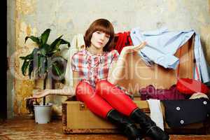 Attractive woman sitting in a suitcase