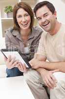 Happy Man & Woman Couple Using Tablet Computer at Home