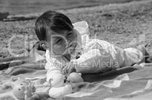 Baby Girl relaxing and playing on a Beach Towel