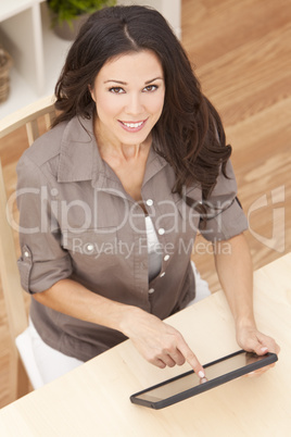 Happy Beautiful Young Woman Using Tablet Computer at Home