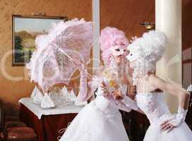 Two girls in wedding dresses and masks