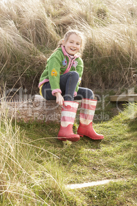 Young Girl Putting On Wellington Boots