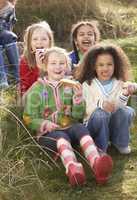Group Of Girls Eating Cream Cakes In Field Together