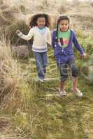 Young Girls Playing In Field Together