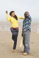 Young Couple Playing Cricket On Autumn Beach Holiday