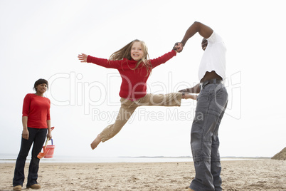 Young Family Relaxing On Beach Camping Holiday