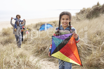 Family Having Fun With Kite In Sand Dunes