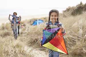 Family Having Fun With Kite In Sand Dunes