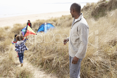 Family Having Fun With Kite In Sand Dunes