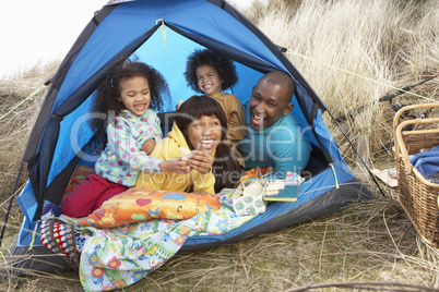 Young Family Relaxing Inside Tent On Camping Holiday