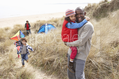 Family Having Fun With Kite In Sand Dunes