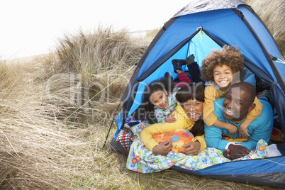 Young Family Relaxing Inside Tent On Camping Holiday