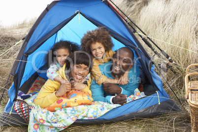 Young Family Relaxing Inside Tent On Camping Holiday