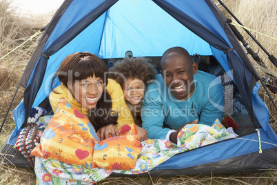 Young Family Relaxing Inside Tent On Camping Holiday